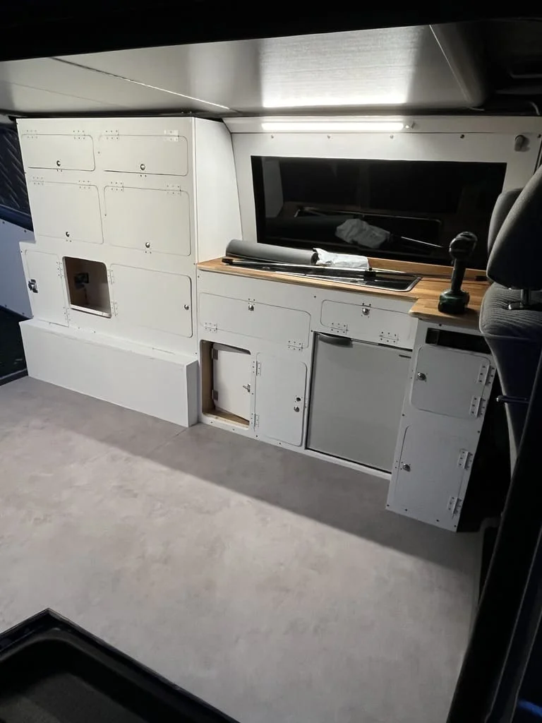 Installer un revêtement de sol en vinyle dans un van aménagé.